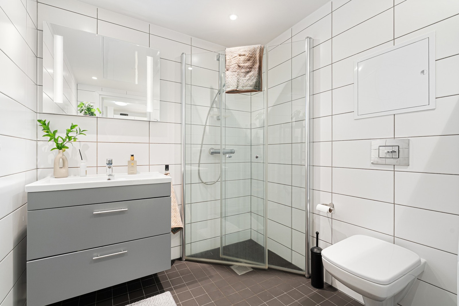 Delikat flislagt bad med varmekabler i gulv og opplegg for vaskemaskin. Galleribilde