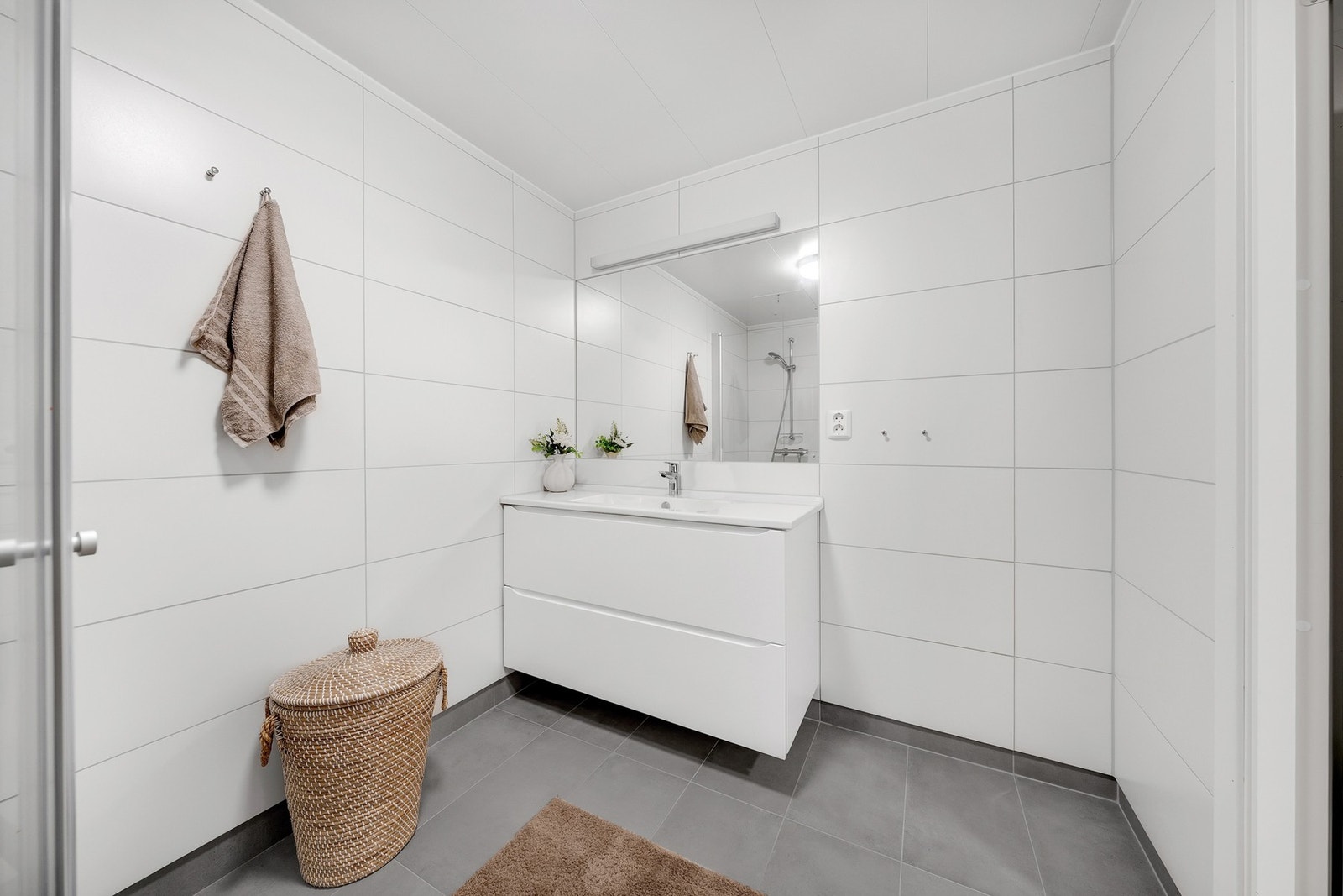 Baderommet er romslig med godt utnyttet plass. Her slipper man å bekymre seg for at vaskemaskin, tørketrommel og tørkestativ tar opp plass, da leiligheten har et eget separat vaskerom. Det er varmekabler i gulvet. Galleribilde