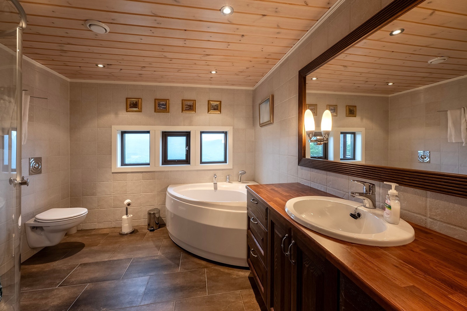 Pent bad med lekre detaljer som baderomsinnredning av heltre eik og varmekabler i gulvet. Galleribilde