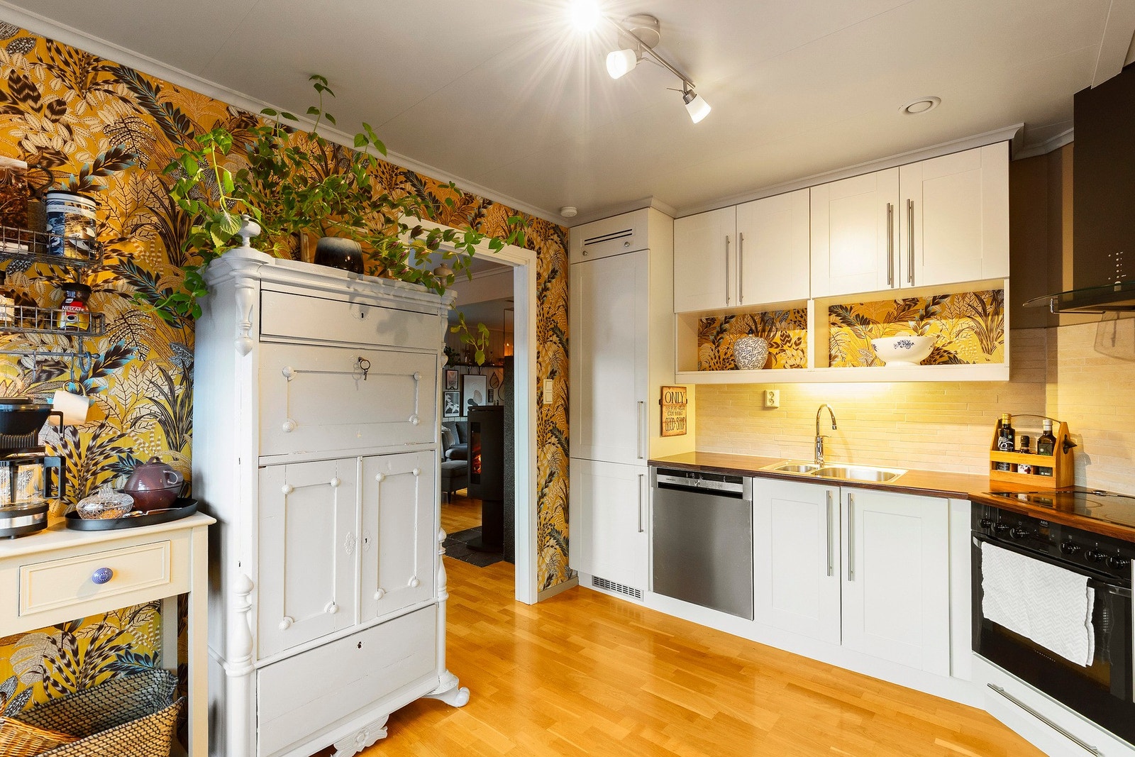 Flis på vegg over benkeplate og malte/tapetserte plater på vegger. Det er parkett på gulv i 1. etasje. Galleribilde