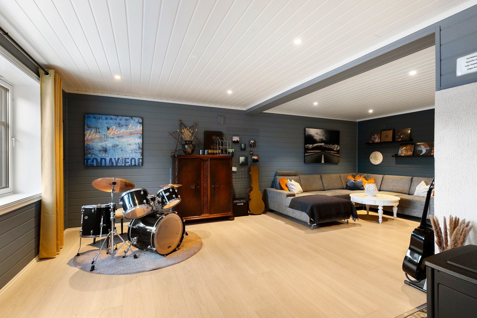 Stort rom i sokkel på 28,5 m² - i dag innredet til stue. Flott laminat på gulv, gulvvarme, vedovn og downlights i himling. Galleribilde