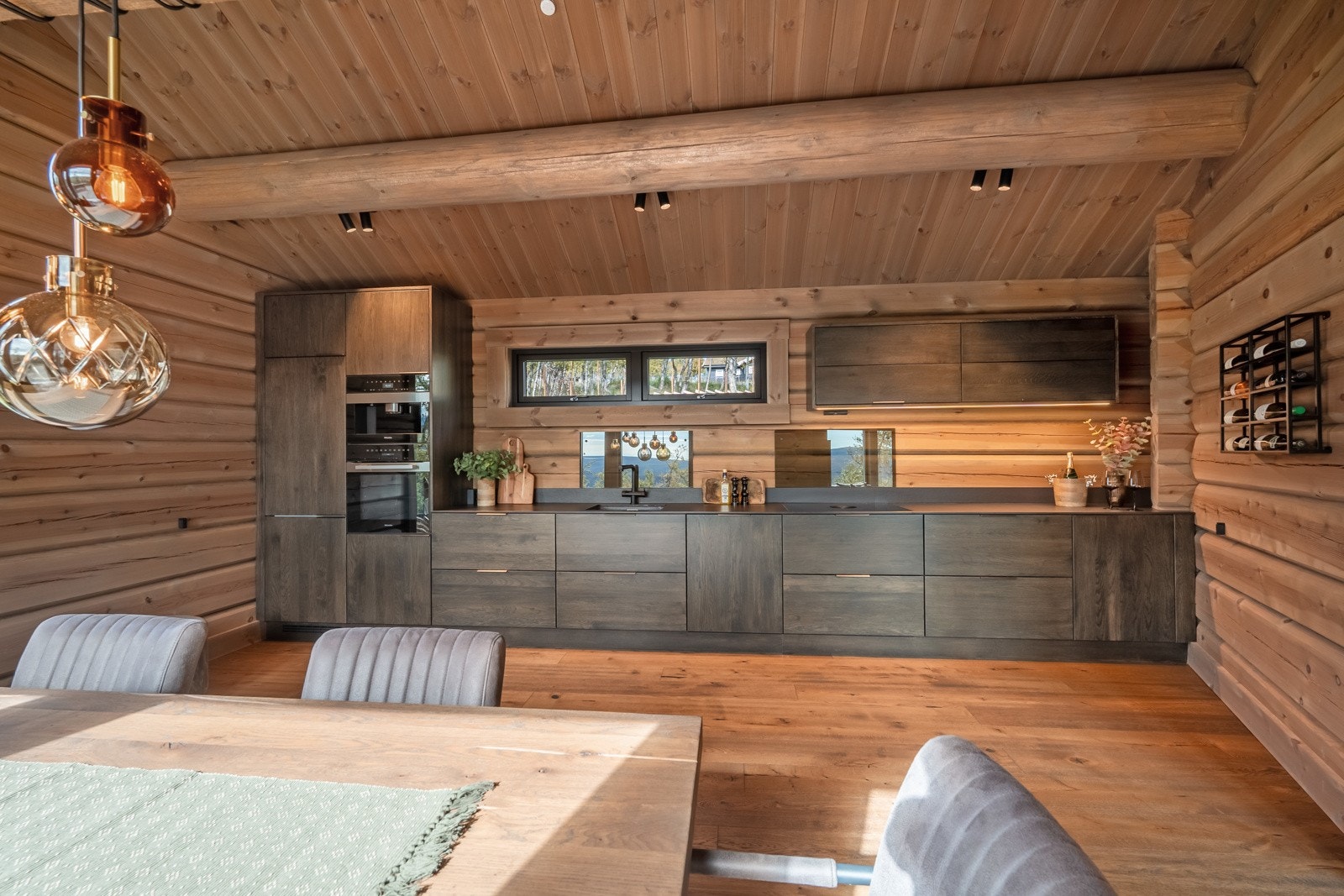 Kjøkkeninnredningen er av heltre eik og er fra Brusveen Snekkerverksted AS, og har rikelig med oppbevaringsplass i brede skuffer og skap med glatte, beisede fronter. Galleribilde