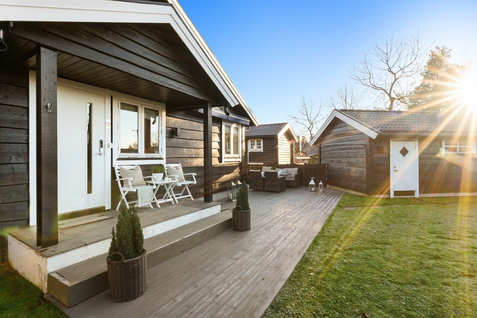 Meget trivelige og velstelte utearealer, praktisk anlagt med hovedterrasse utenfor kjøkkenet, mellom garasjen og boligen Galleribilde