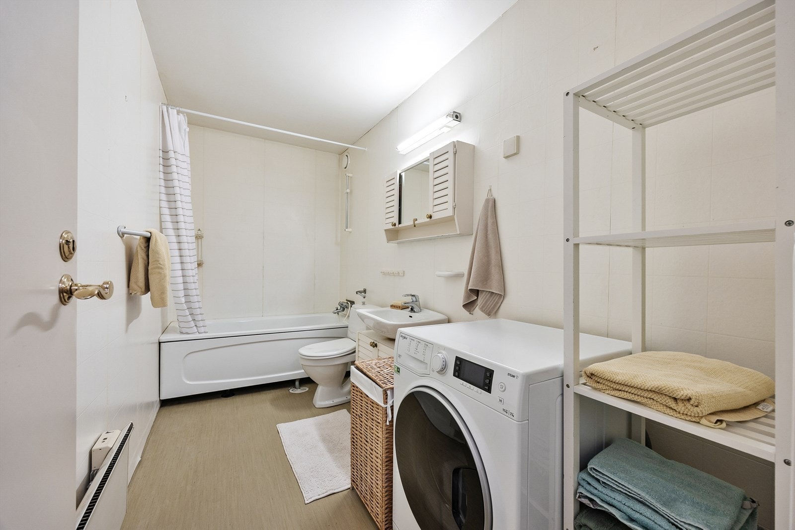 Badet er funksjonelt innredet med badekar og opplegg for vaskemaskin. Galleribilde