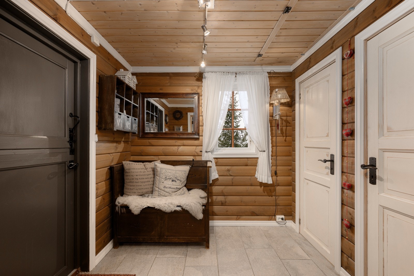 Entréen har flislagt gulv og beiset panel på veggene. Galleribilde