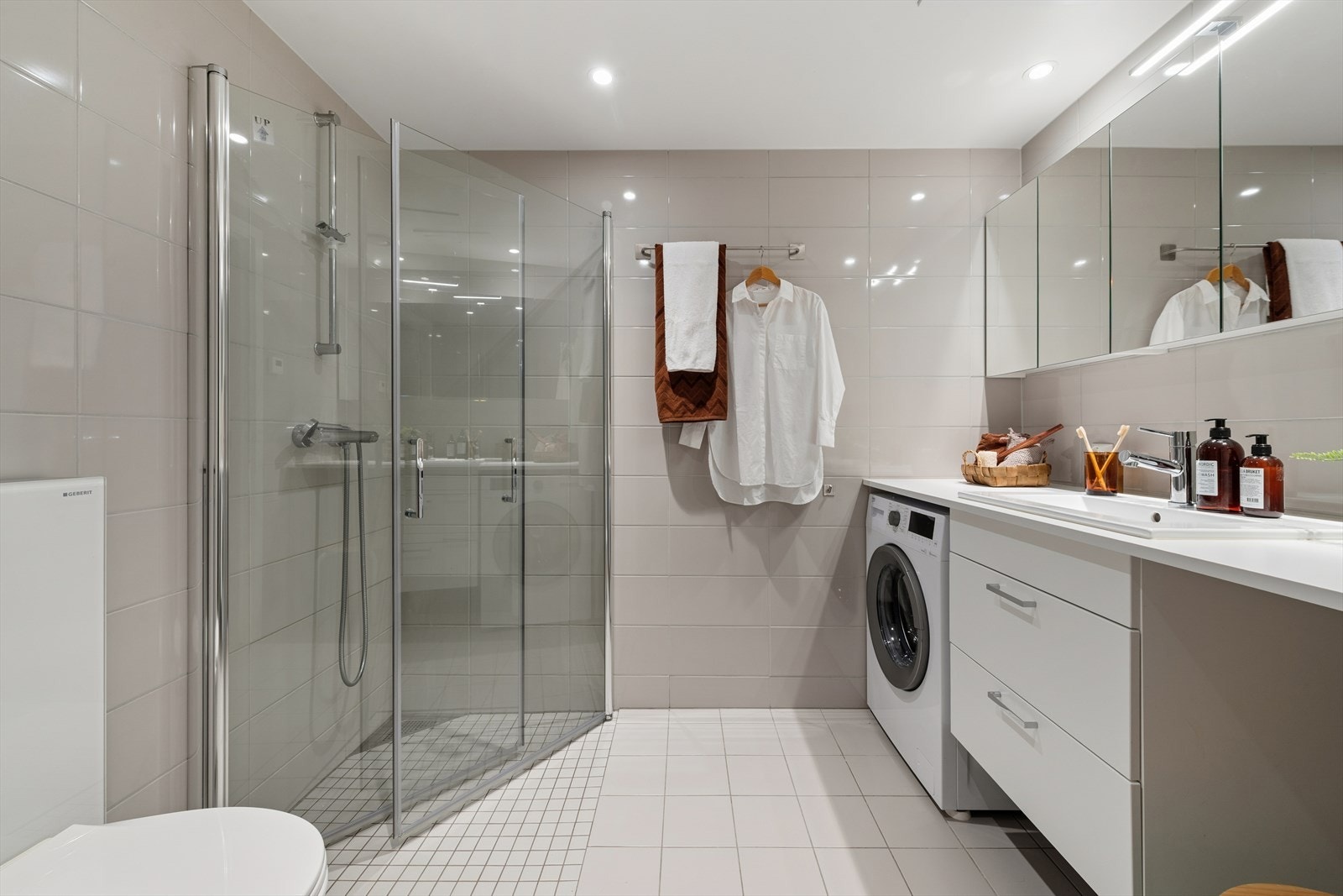 Pent, flislagt baderom med termostatstyrt gulvvarme og glattmalt himling med downlights. Galleribilde