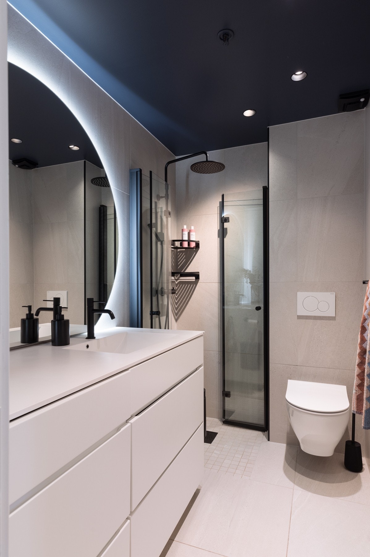 Badet har vegghengt klosett, dusj med innfellbare dusjdører, integrert kombimaskin og moderne baderomsinnredning med heldekkende servant. Galleribilde