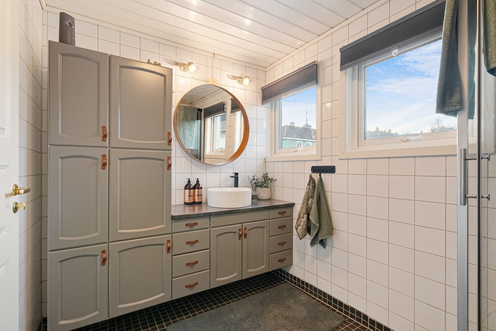 Delikat flislagt baderom med innholdsrik baderomsinnredning. Galleribilde