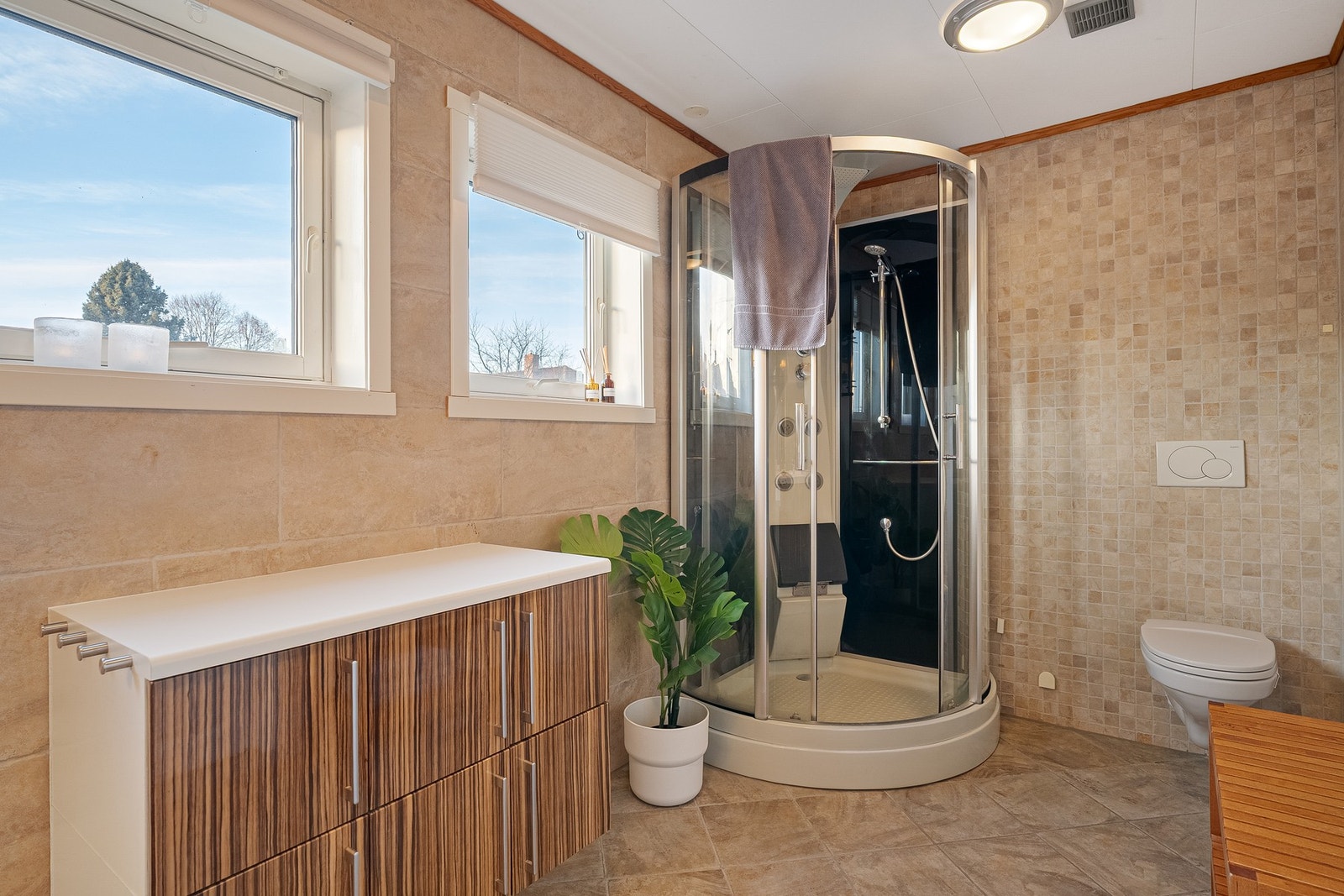 Baderommet har vegghengt toalett og dusjkabinett. Galleribilde