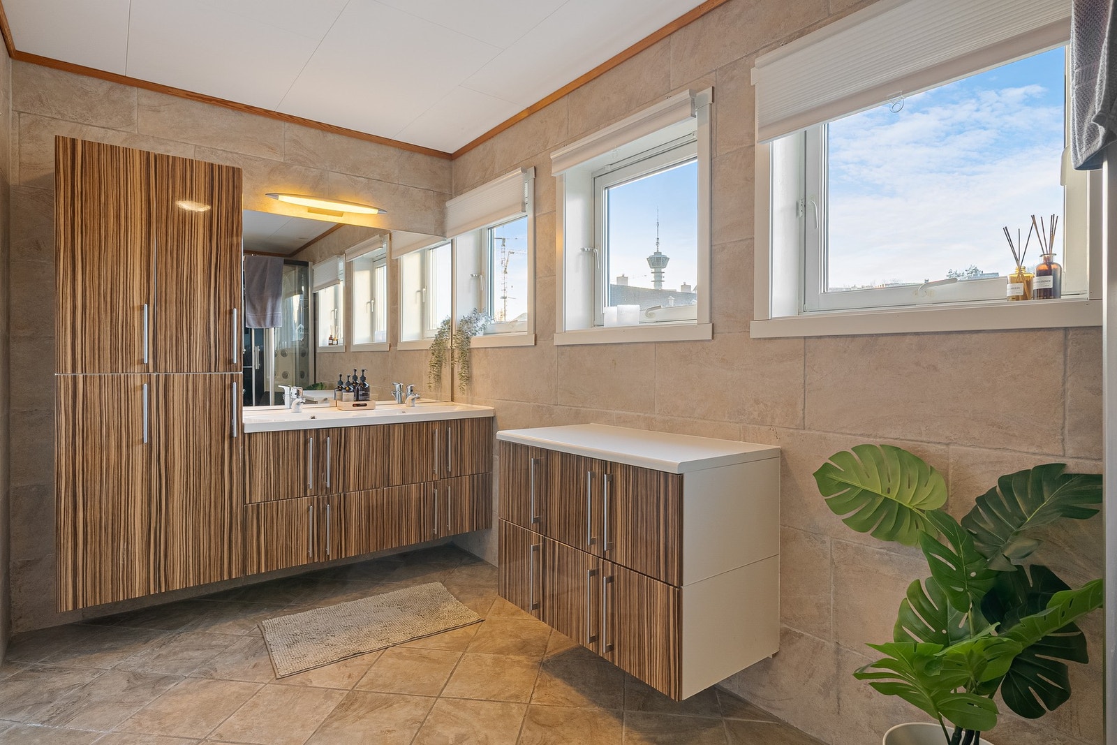 Stort baderom på 8 kvm med varme i gulv, innholdsrik innredning og store vinduer. Galleribilde