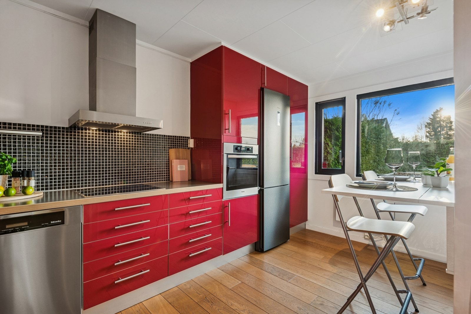 Kjøkkeninnredningen er fra 2010 og fremstår som pen og funksjonell, med røde, glatte fronter og laminert benkeplate med helstøpt servant og kum. Galleribilde