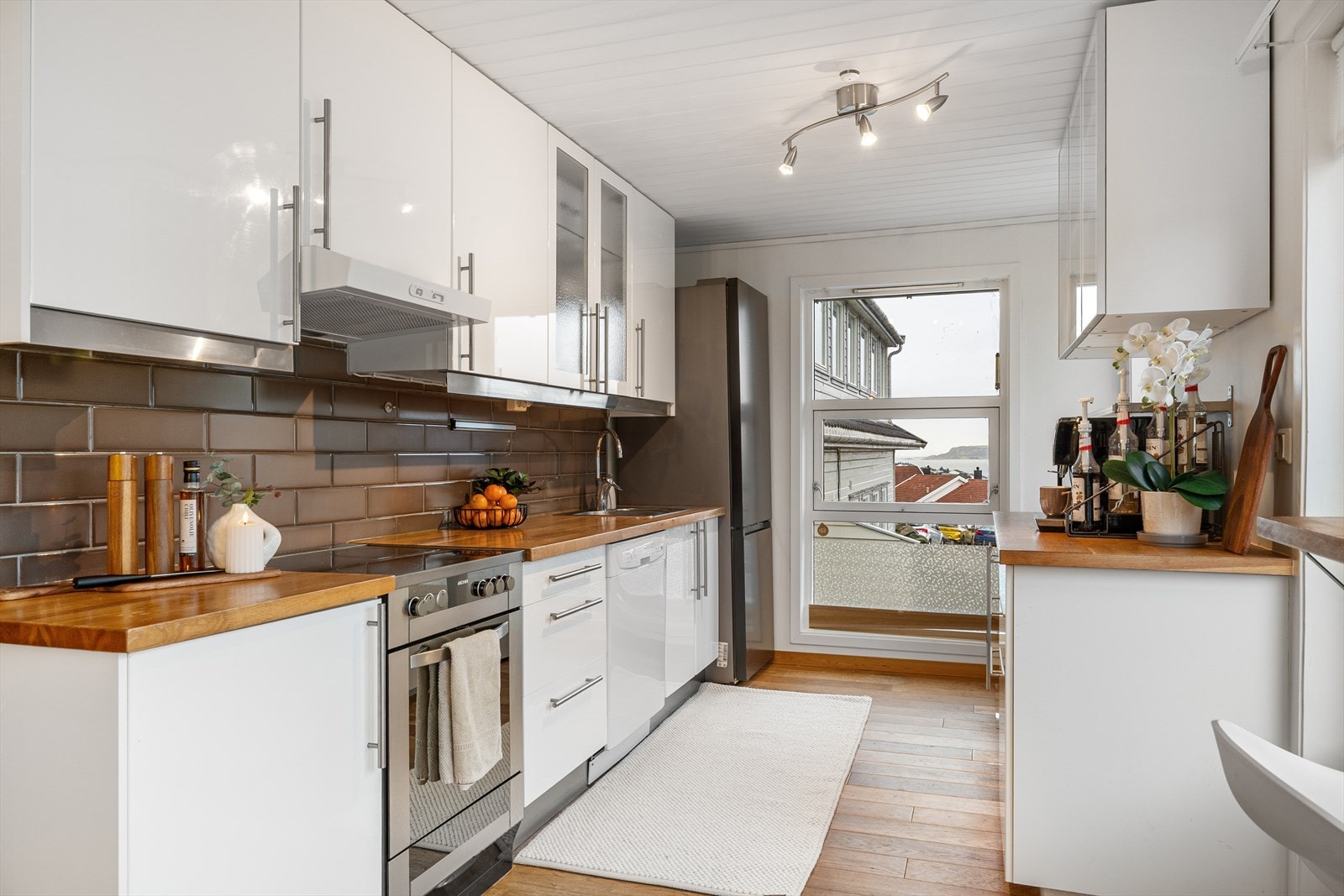 Kjøkkenet har rikelig med skapplass og en tidløs utførelse med hvite fronter og benkeplate i tre. Galleribilde