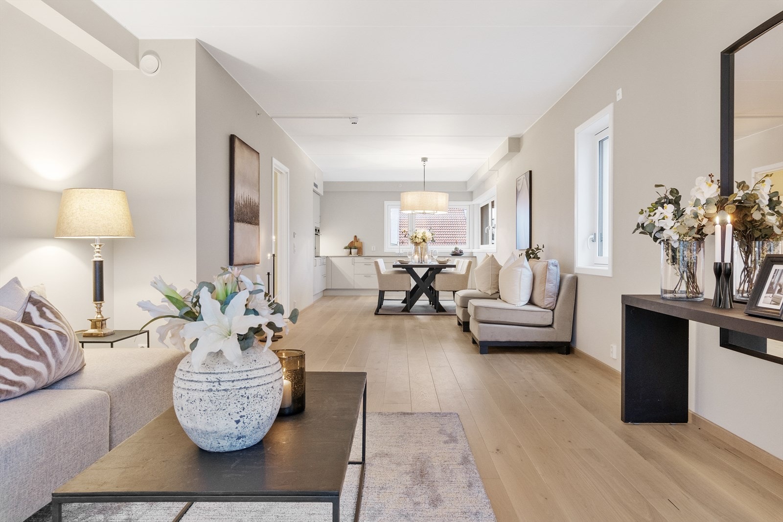 Elegant overgang mellom stue, loungeområde og spiseplass. De gjennomgående materialene og varme tonene skaper en harmonisk atmosfære. Her er det lett å se for seg hyggelige sammenkomster. Galleribilde