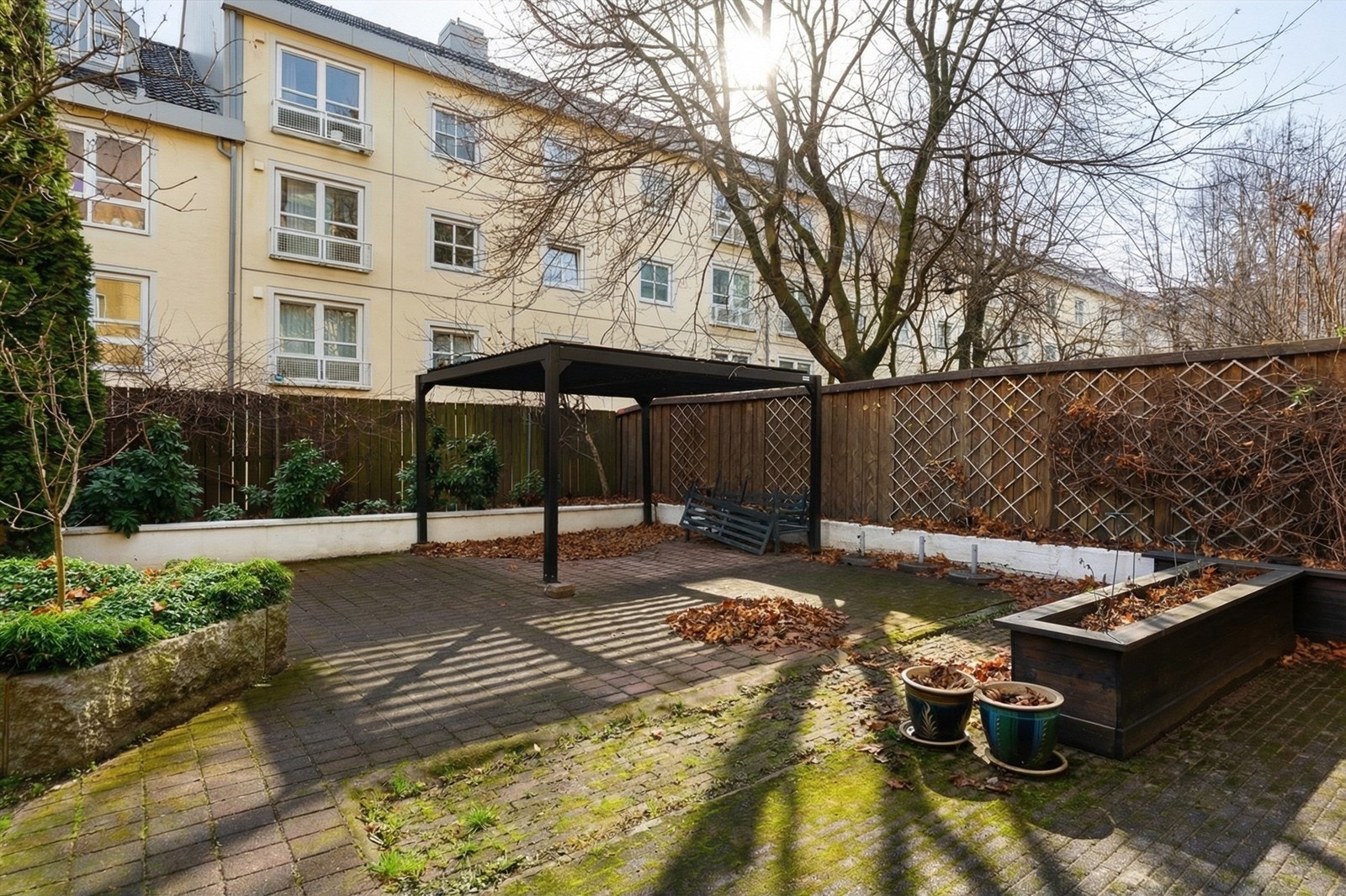 Felles uteplass med pergola, tilgjengelig for beboerne. Galleribilde