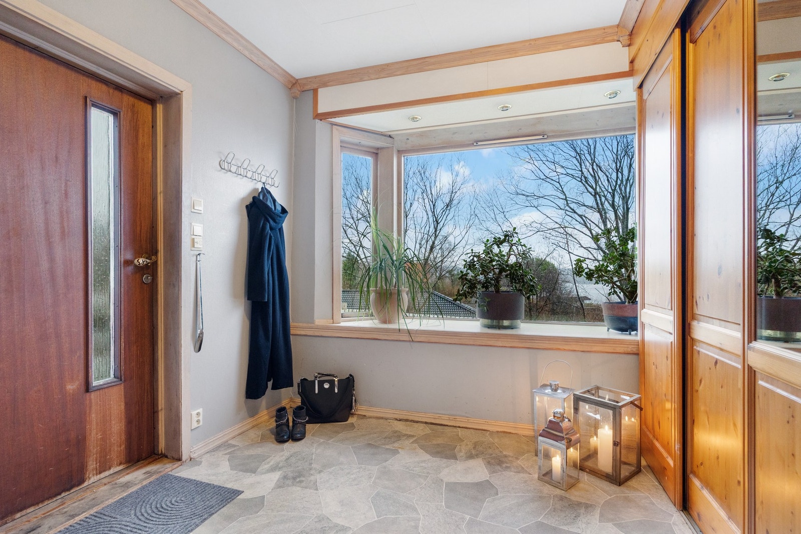 Romslig entré med stort vindu i front og praktisk skyvedørsgarderobe. Galleribilde