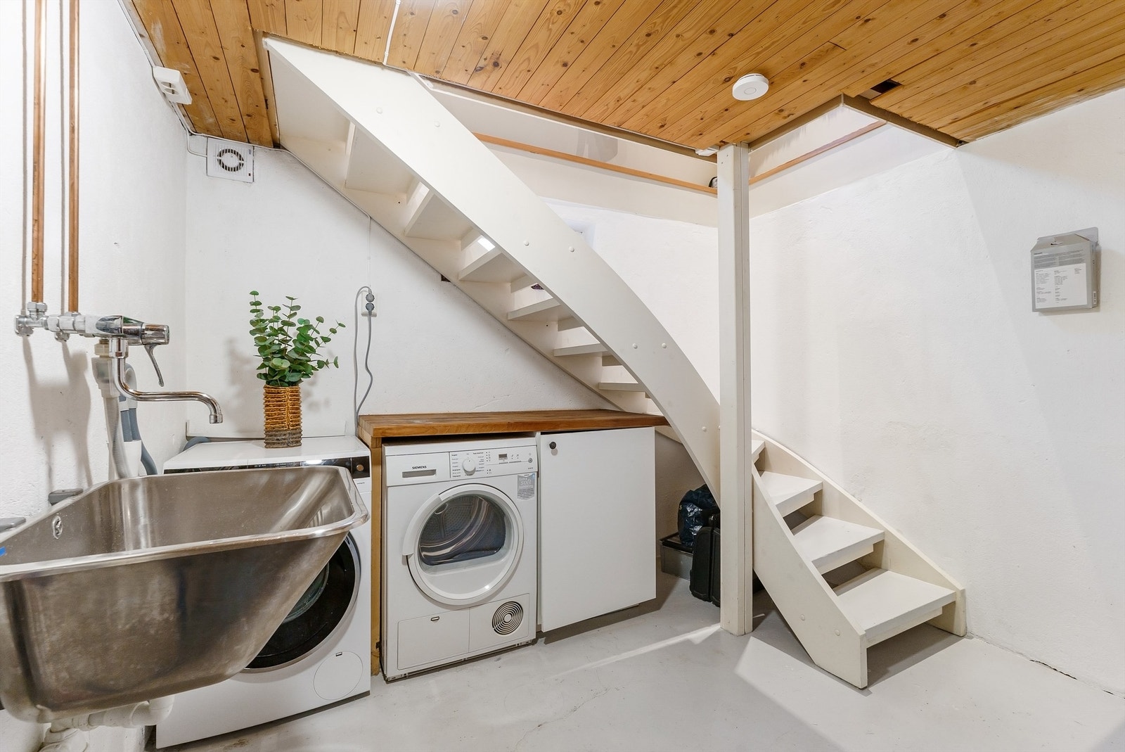 Praktisk vaskekjeller med opplegg for vaskemaskin og tørketrommel. Galleribilde