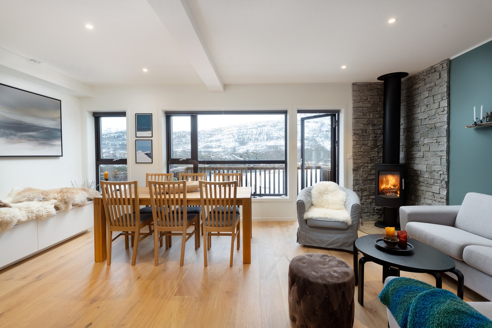 Stuen har ekstra spotter i taket, enstavs parkett på gulv og skiferstein bak peisen Galleribilde