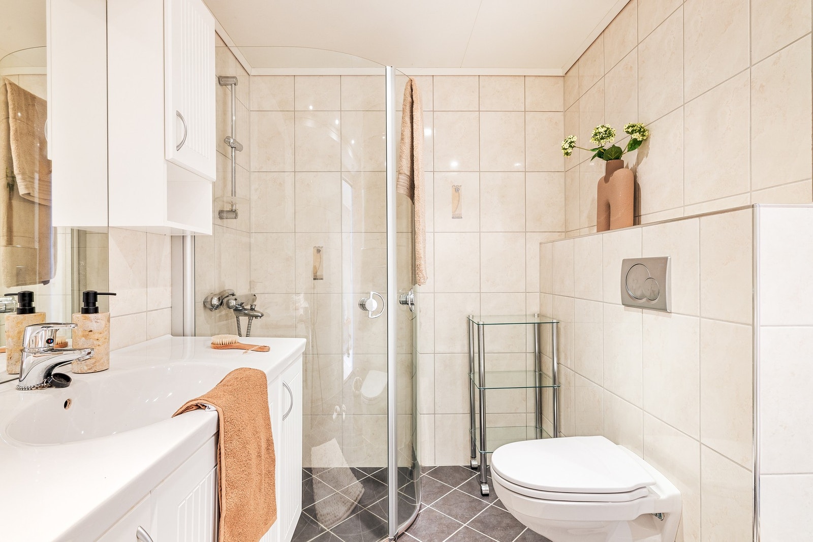 Videre inneholder badet servant med møblement/speil, belysning, vegghengt toalett, dusjhjørne og opplegg for vaskemaskin. Galleribilde