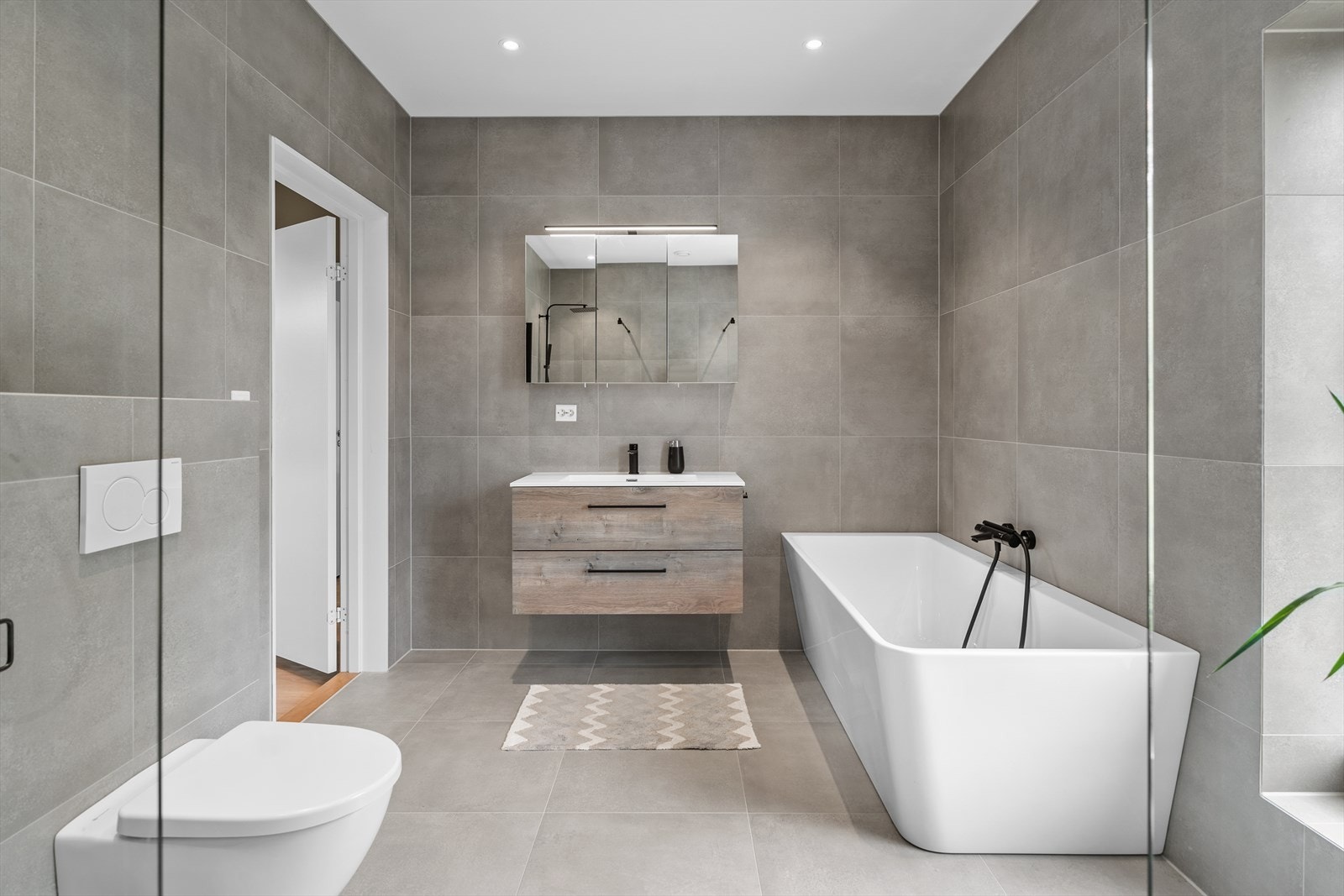 Flislagt bad med nedfelt servant og moderne baderomsinnredning Galleribilde