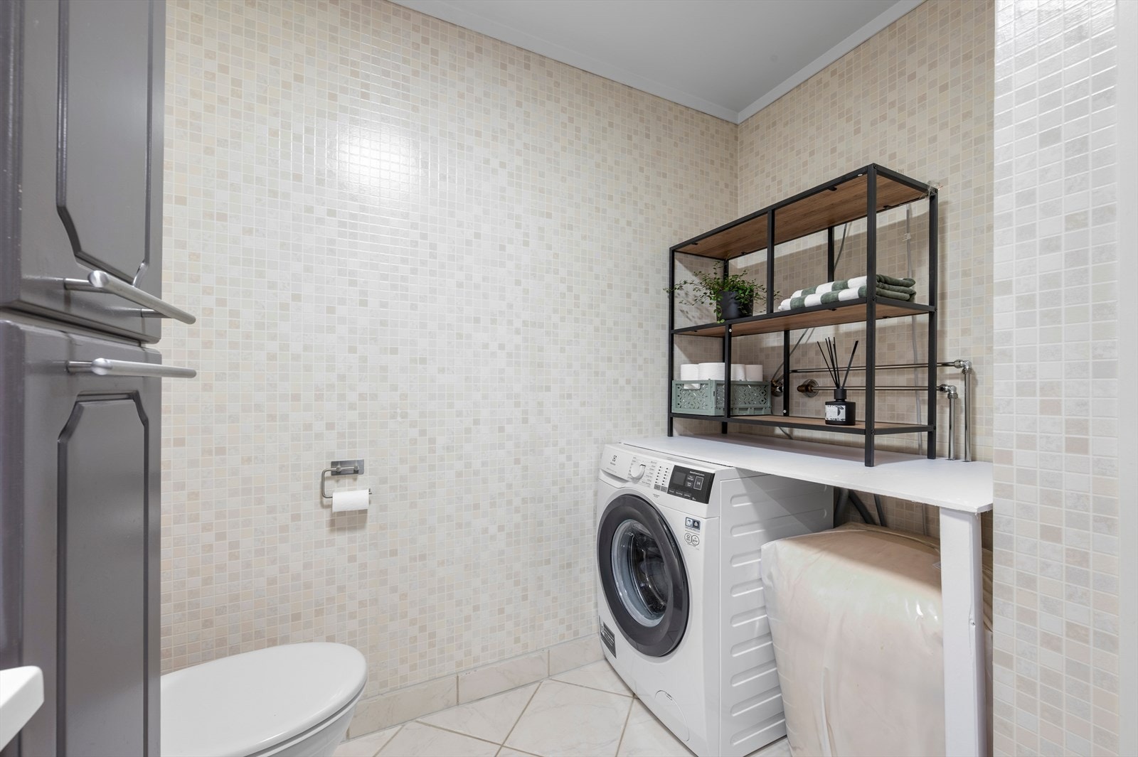 Videre er badet utstyrt med dusjkabinett, toalett og rommet har opplegg for vaskemaskin. Galleribilde