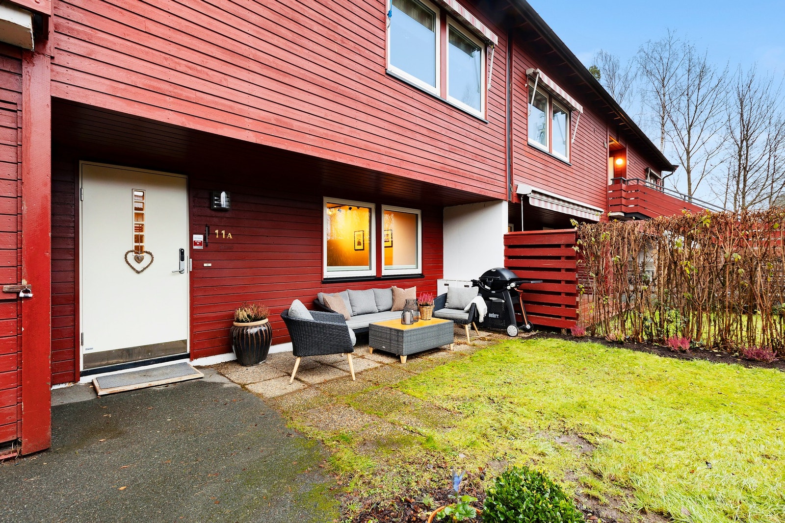 Boligen har et innbydende inngangsparti med en steinbelagt platting som enkelt kan møbleres Galleribilde