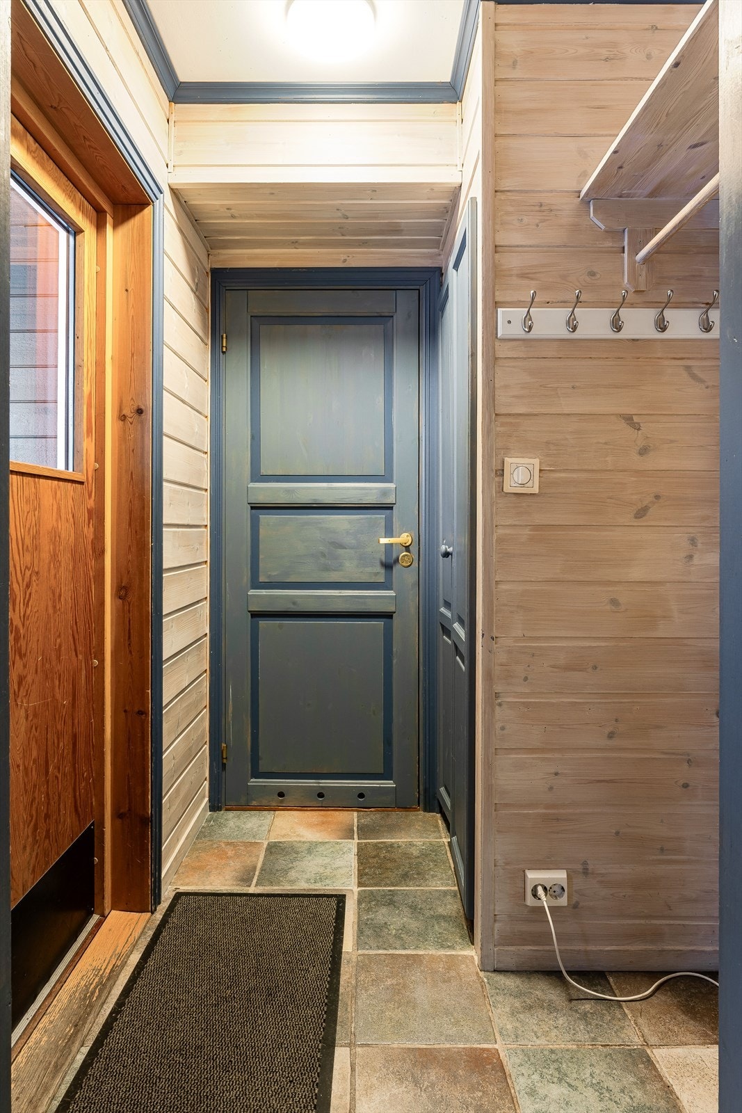 Gang med flislagt gulv og godt med plass for kommode for yttertøy og sko. Galleribilde