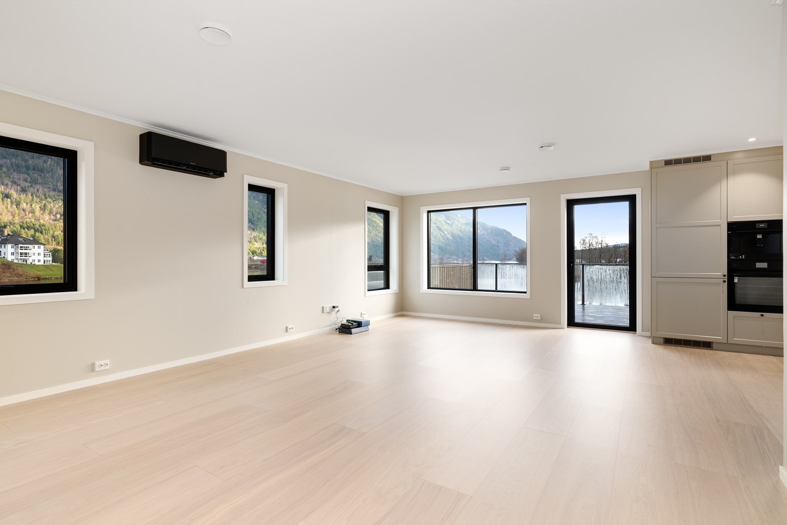 Stuen er stilren og moderne med store vindusflater som slipper godt med naturlig lys inn. De store vindusflatene gjør også at den fantastiske utsikten og det nydelige nærområdet kan nytes inne fra boligen. Galleribilde