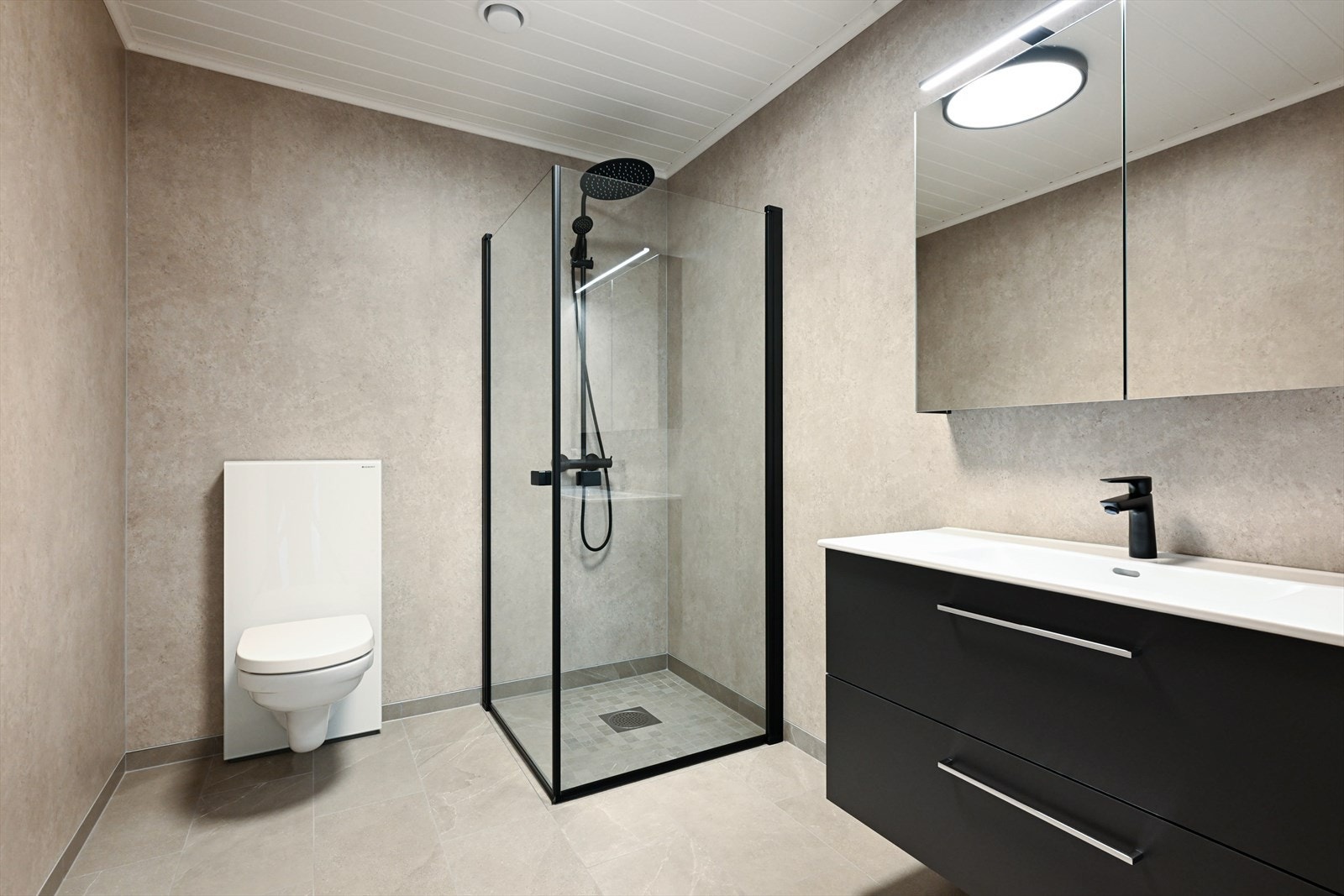 Flott og oppgradert bad med flis på gulv og Fibo baderomsplater på vegger. Badet har vegghengt toalett, dusjhjørne med dører og innredning fra Fossbad med heldekkende hvit vask, underskuffer med slette fronter og overskap med speildører. Varmekabler. Galleribilde