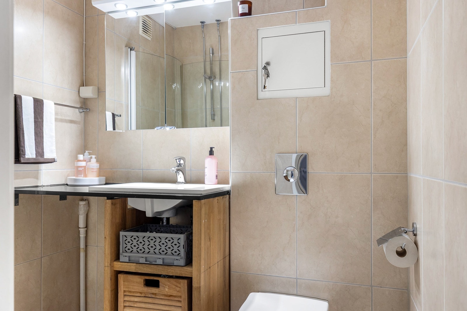 Badet er av god størrelse. Gulv og vegger er belagt med lyse fliser, som gir et delikat uttrykk. Galleribilde