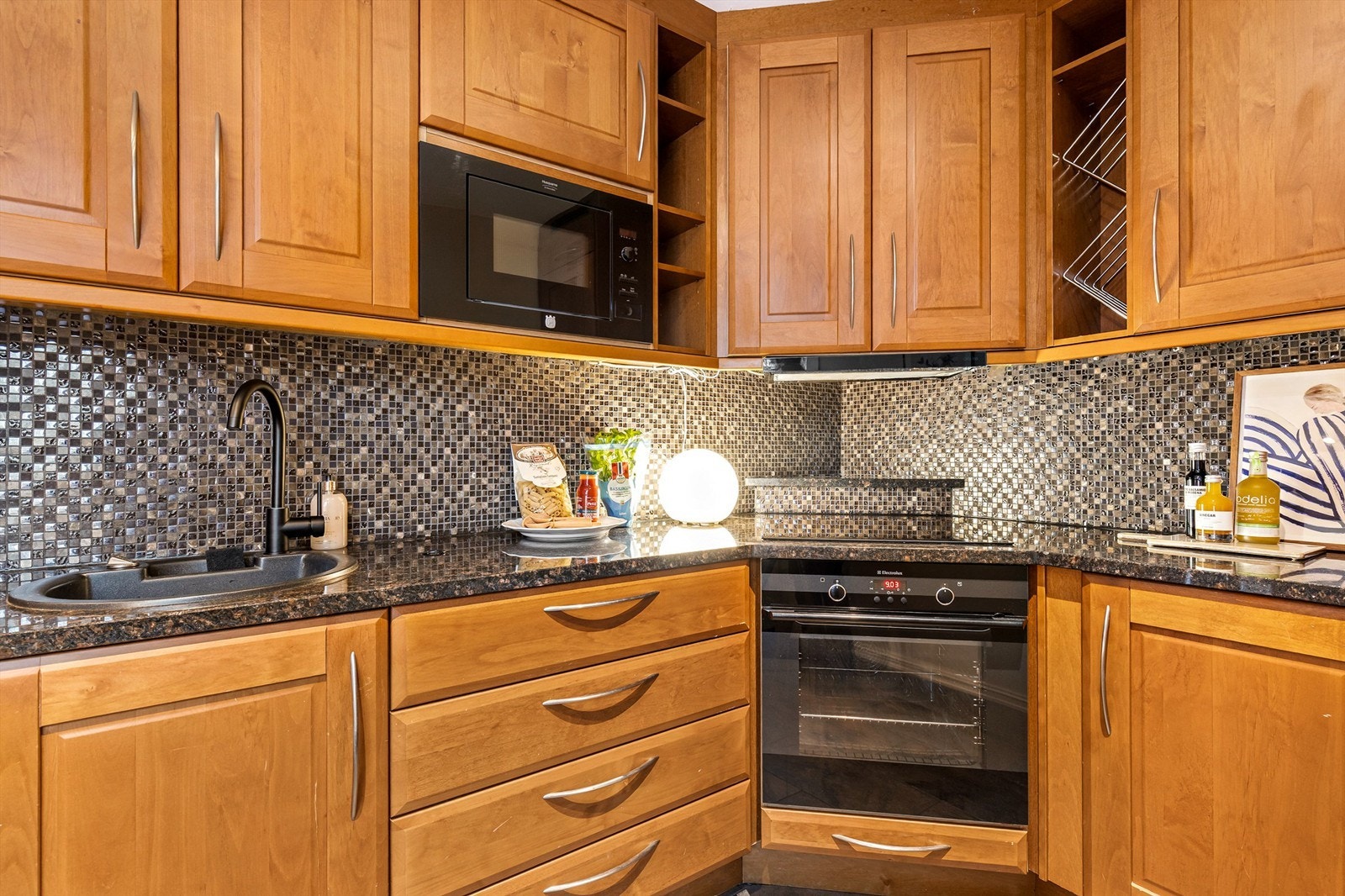 Kjøkkenet er utstyrt med integrerte hvitevarer bestående av induksjonstopp, stekeovn, mikrobølgeovn, oppvaskmaskin samt kombinert kjøl- og fryseskap. Over koketoppen er det montert kullfilterventilator som sørger for god ventilasjon under matlaging. Galleribilde