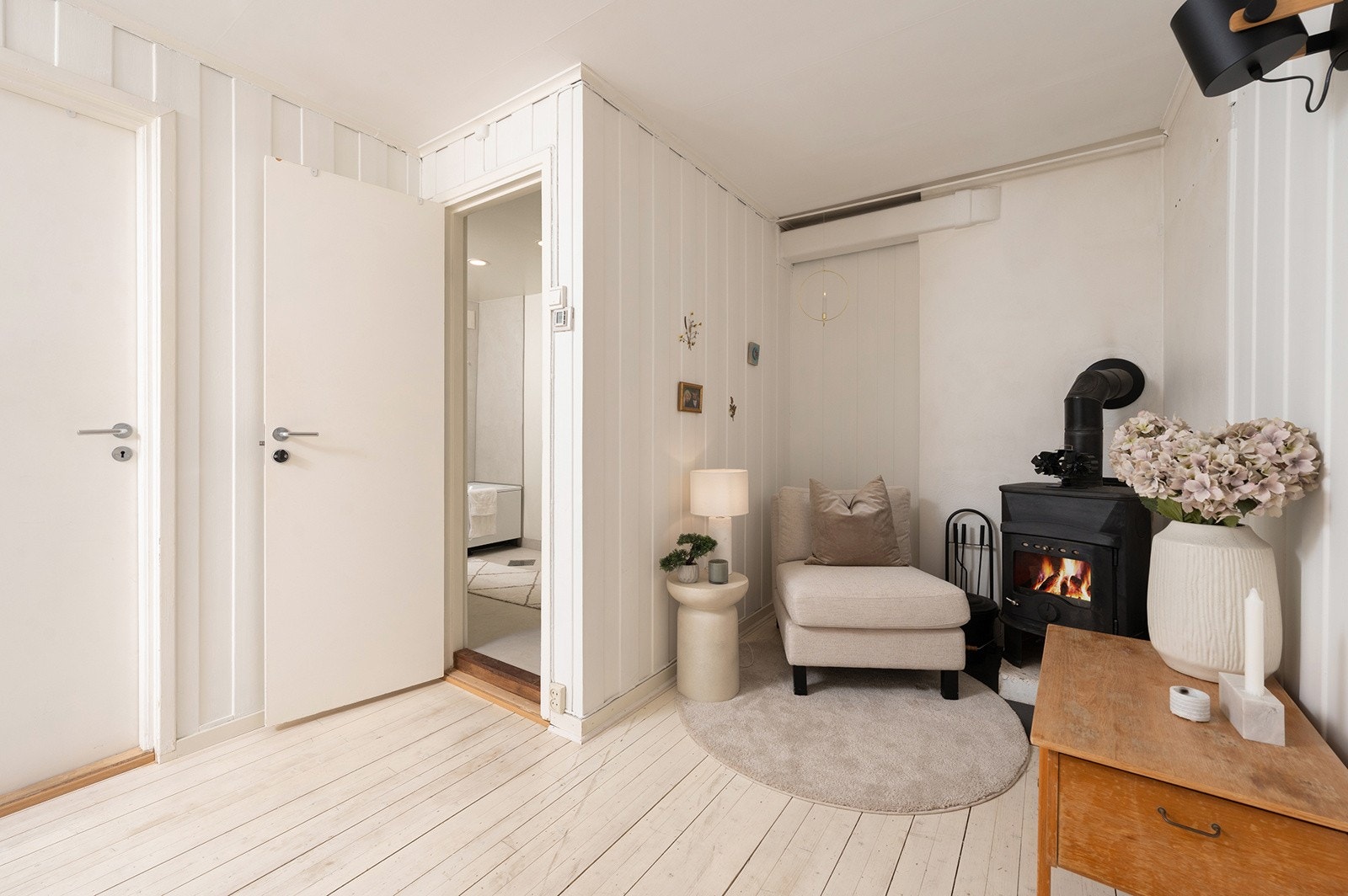 I et hjørne av rommet er det montert peisovn som skaper en varm og hyggelig atmosfære allerede ved adkomst til boligen. Galleribilde