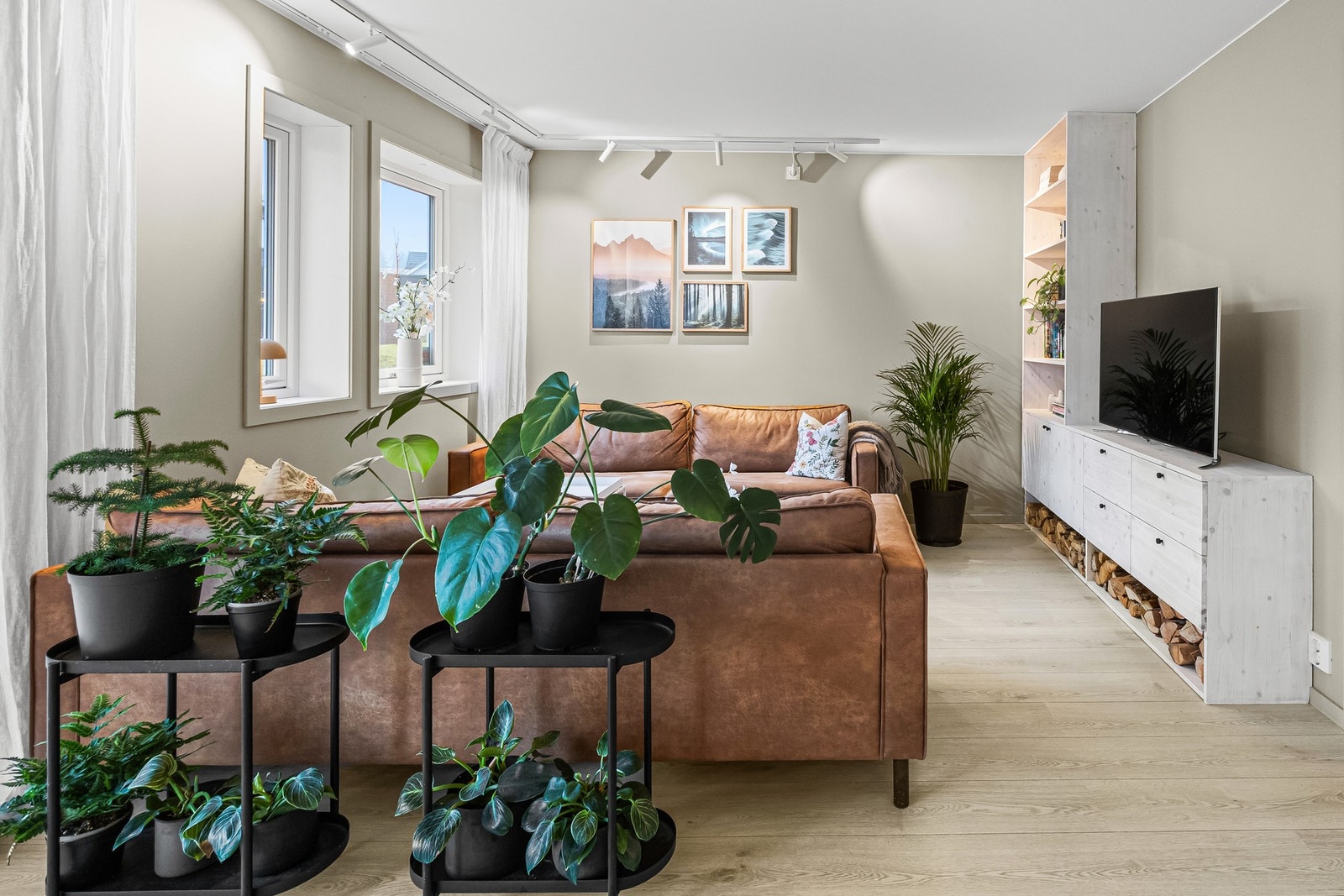 På gulvet er det lagt lyspigmentert laminat som strekker seg inn i kjøkken og soverommene. I stuen er det en integrert tv-benk/bokhylle. Galleribilde