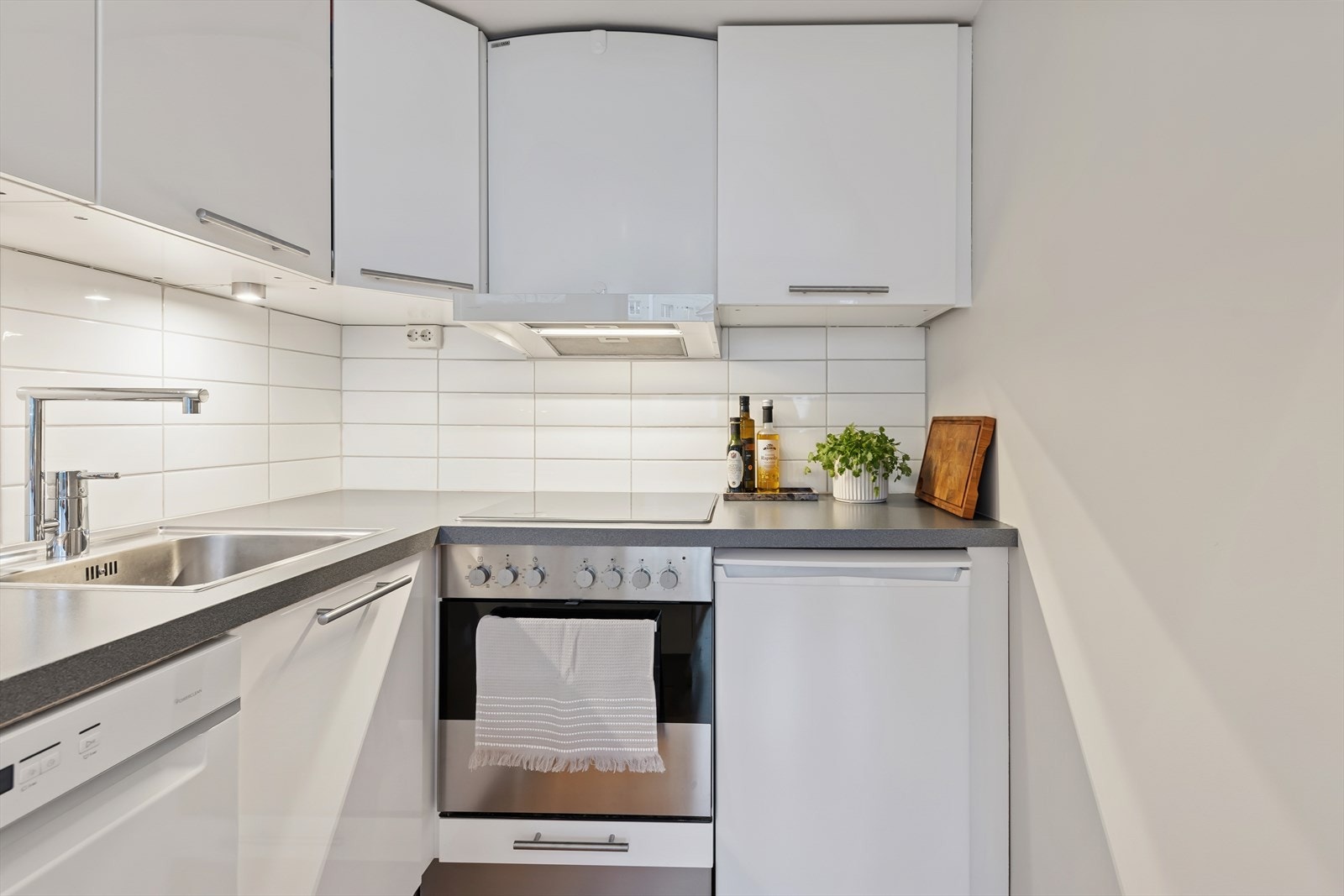 Kjøkkenet er ellers utstyrt med kjøleskap (2025), oppvaskmaskin (2023), stekeovn, koketopp og kjøkkenventilator med avtrekk via sentralt avtrekksanlegg i blokken som alle medfølger boligen. Galleribilde