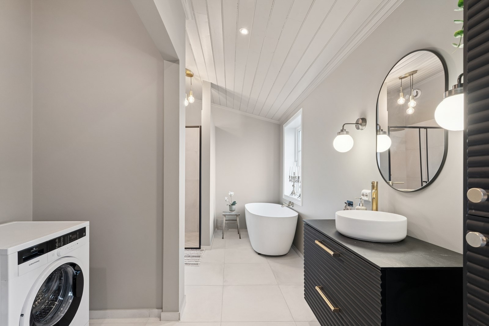 Badet har også et vegghengt toalett og opplegg for vaskemaskin. Galleribilde