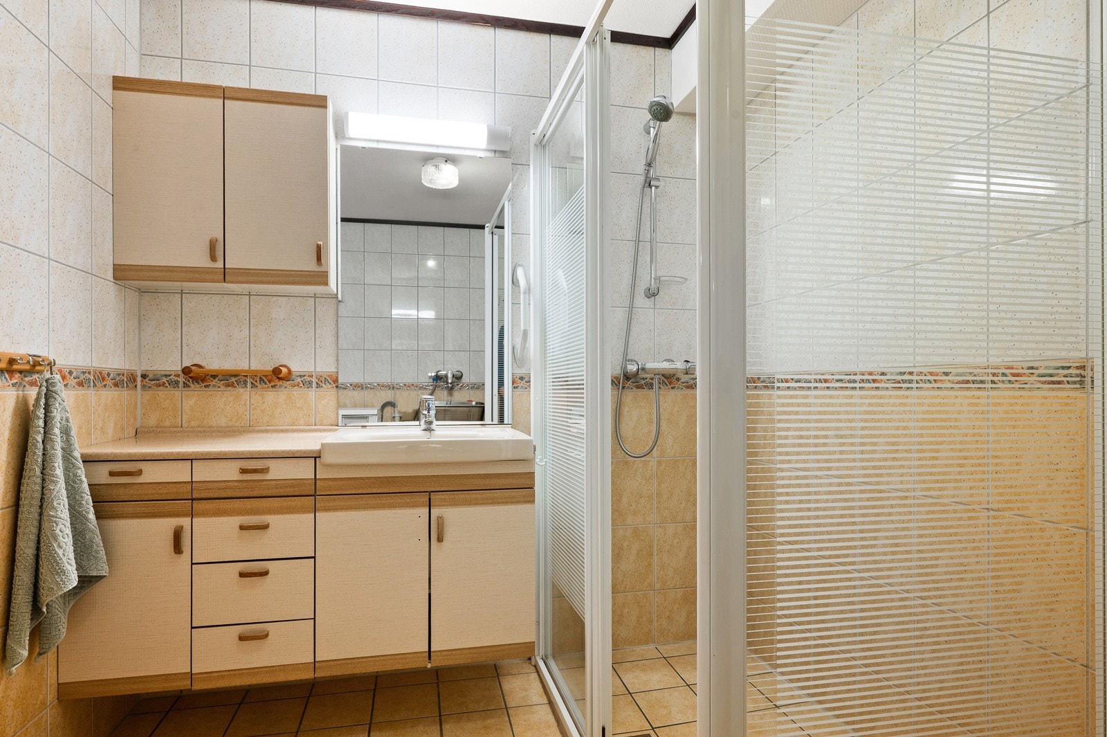 Badet er innredet med servant i seksjon, dusjhjørne og gode oppbevaringsmuligheter. Galleribilde