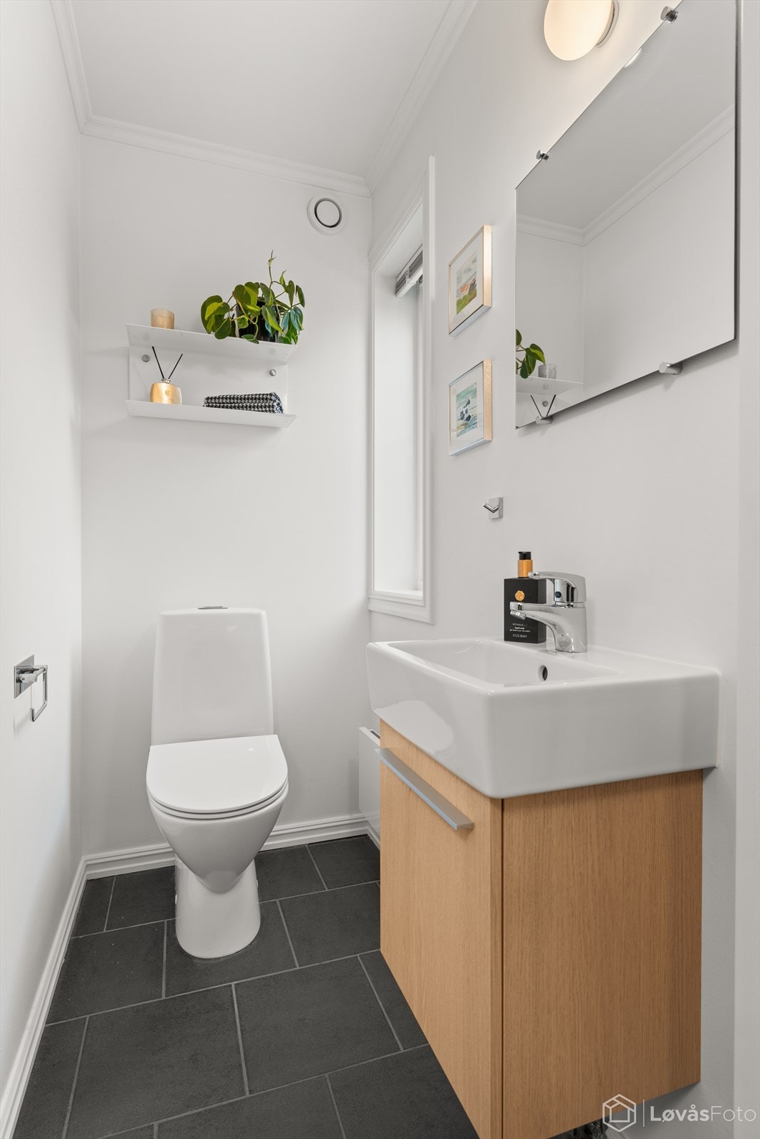 Separat toalettrom i første etasje, praktisk plassert ved entréen. Innredningen, som ble oppgradert med ny servant og skap i 2016, består av en vegghengt servant og et frittstående toalett. Galleribilde