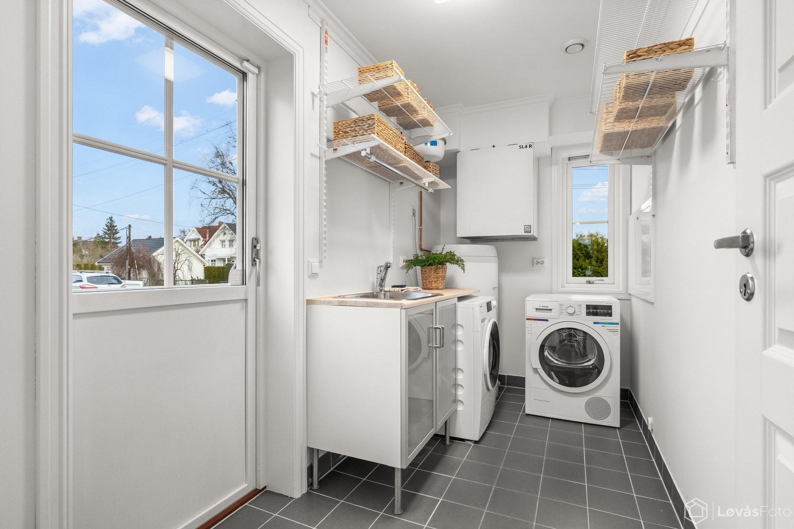 I direkte tilknytning til kjøkkenet finner du et praktisk vaskerom med egen utgang, flislagt gulv med varme og opplegg for vaskemaskin. Galleribilde