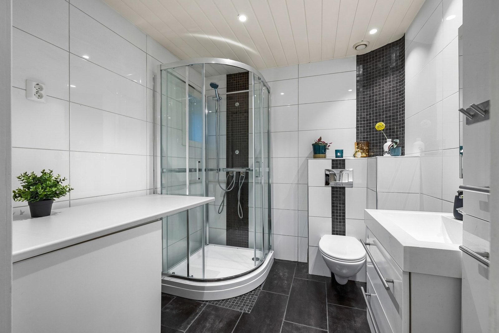 Baderom med flislagte overflater på gulv og vegger. Dusjkabinettet er nytt i 2025 Galleribilde