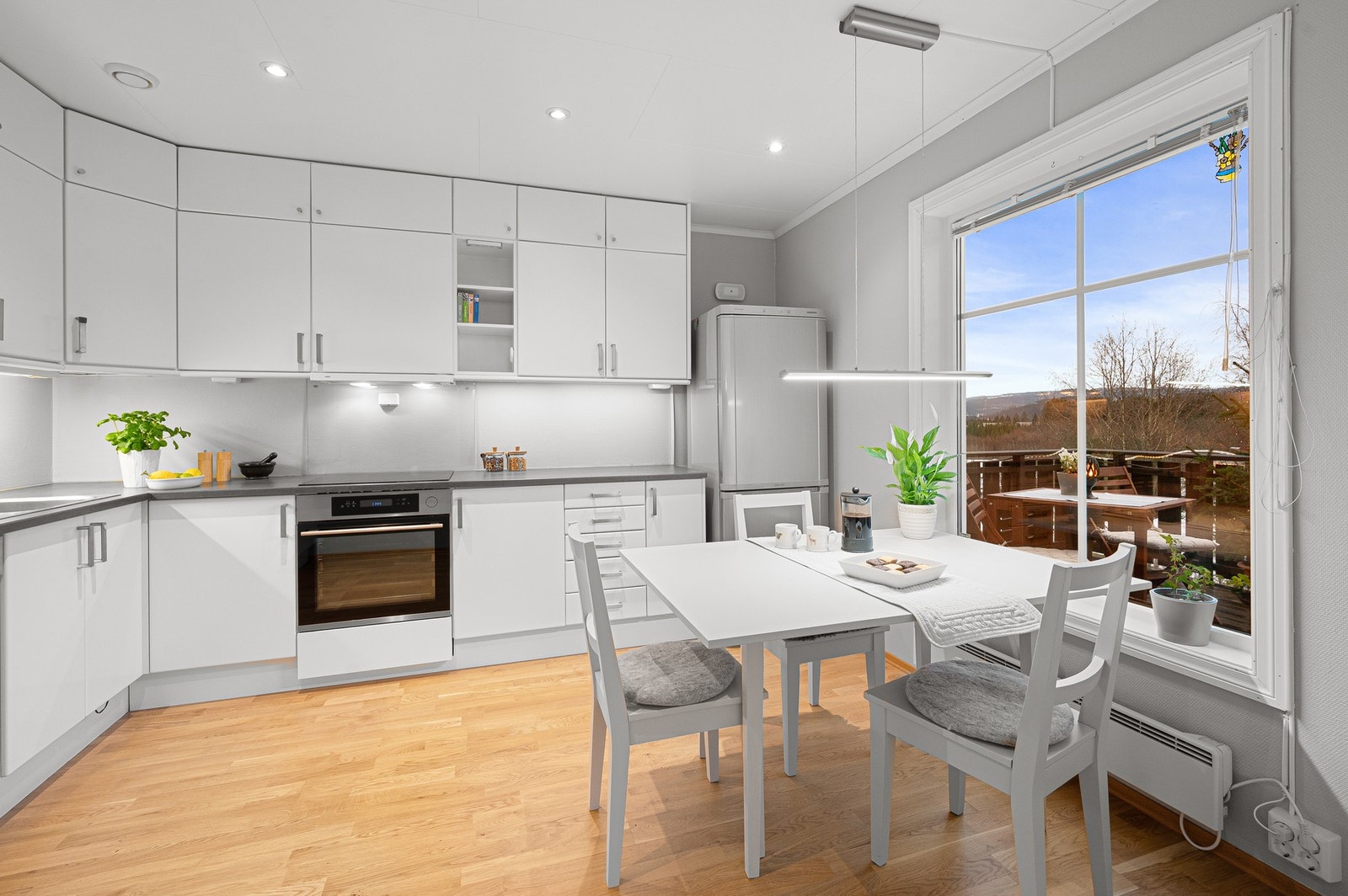 Pent kjøkken med mye skap og benkeplass. Galleribilde