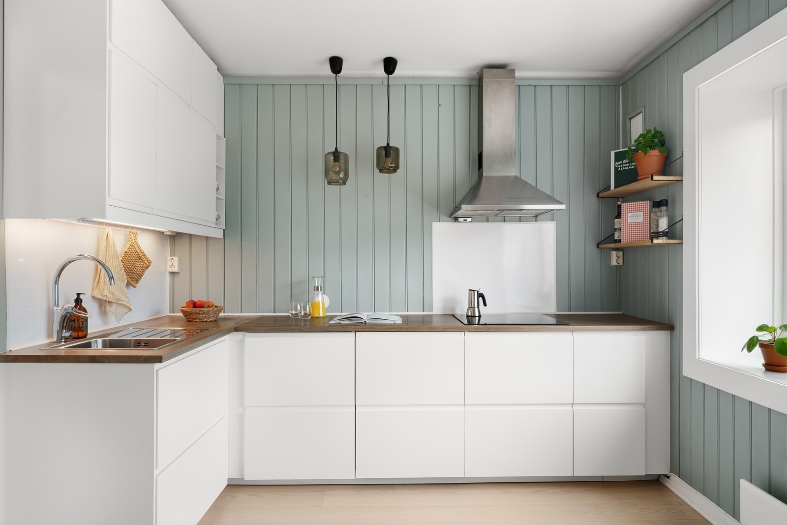 Innredningen består av hvite glatte fronter og benkeplater i laminat med nedfelt oppvaskkum Galleribilde