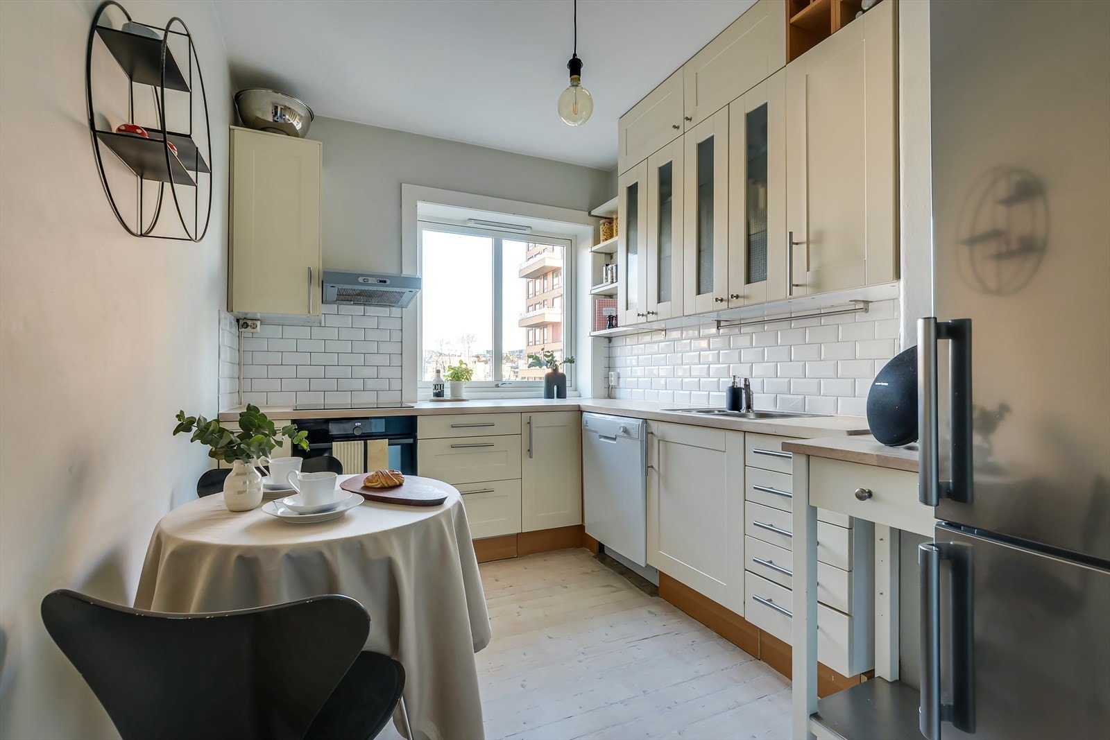 Det lyse kjøkkenet er innredet med profilerte fronter og heltre benkeplate med nedfelt stålkum. Galleribilde