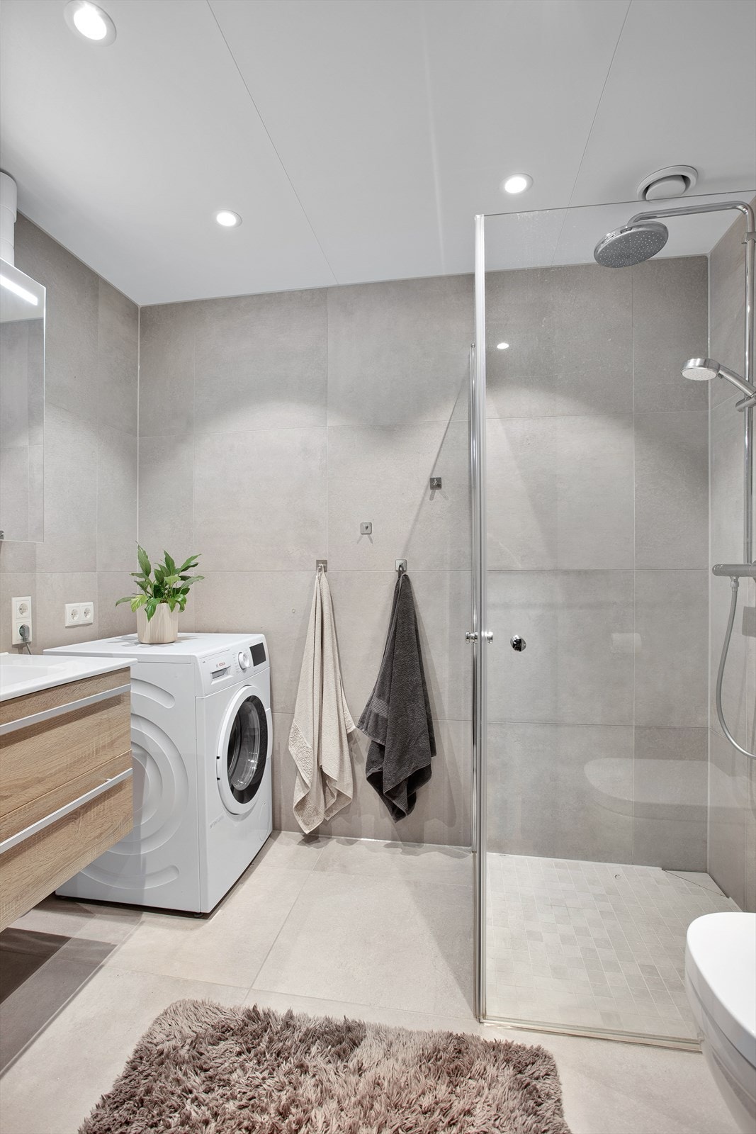 Flislagt bad med gulvvarme. Innredet med vegghengt servantinnredning med skuffer og ovenpåliggende servant. Galleribilde