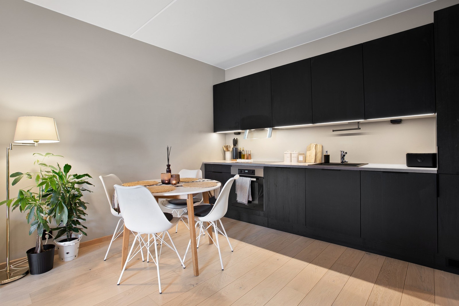 Pent kjøkken med innredning med slette fronter. Benkeplate av laminat med nedfelt oppvaskkum. Galleribilde