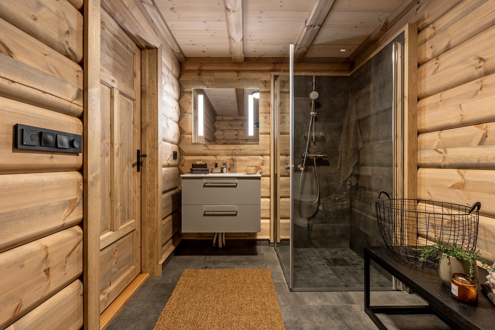 Begge badene har flislagt gulv og flis på vegg i dusjsonen. Tømmer på øvrige vegger og panel i himlingen. Galleribilde