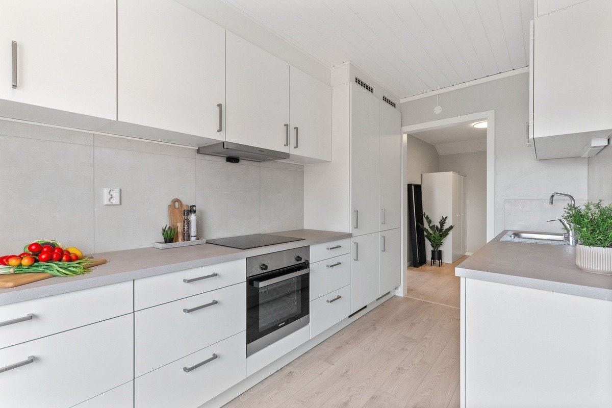 Leilighetens kjøkken - inngangspartiet skimtes i enden gjennom døråpningen Galleribilde