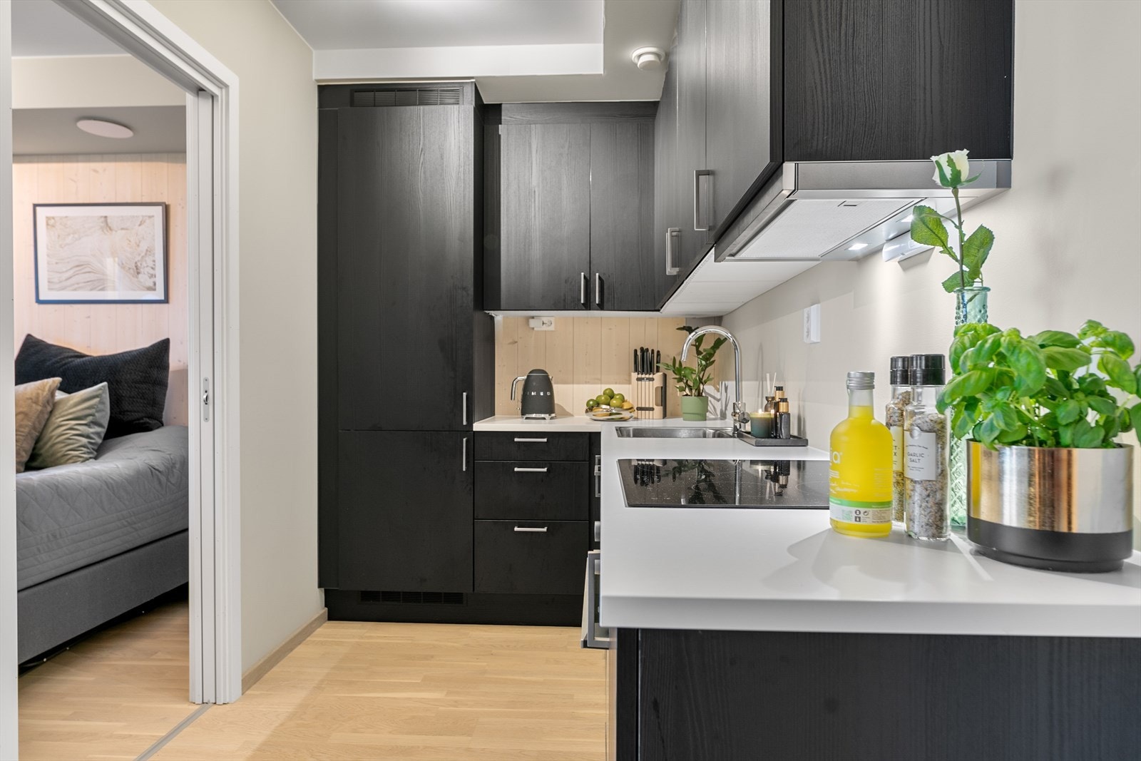 I hjørne av rommet er den lekre kjøkkeninnredningen praktisk plassert.
Innredningen er fra HTH med svarte fronter og laminat benkeplate. Galleribilde