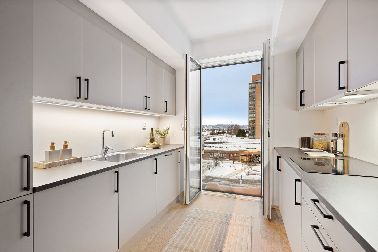 Tidløst korridorkjøkken fra HTH med god skapplass og naturlig lys fra fransk balkong. Galleribilde