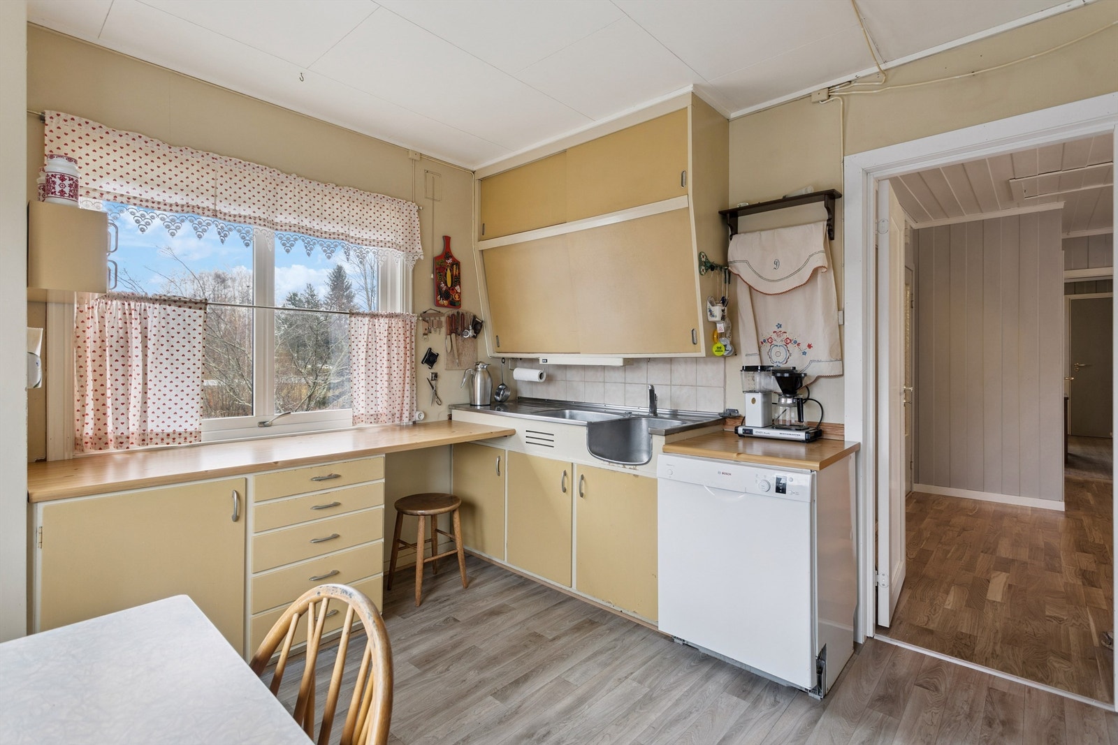 Kjøkkenet har en praktisk, separat løsning med innredning fra byggeåret. Galleribilde