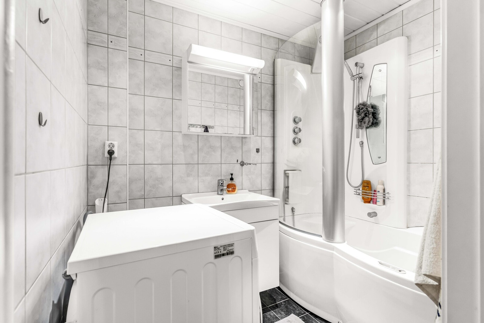 Baderommet har flislagt gulv med elektriske varmekabler. Rommet er innredet med servant, boblebad samt opplegg for vaskemaskin. Galleribilde