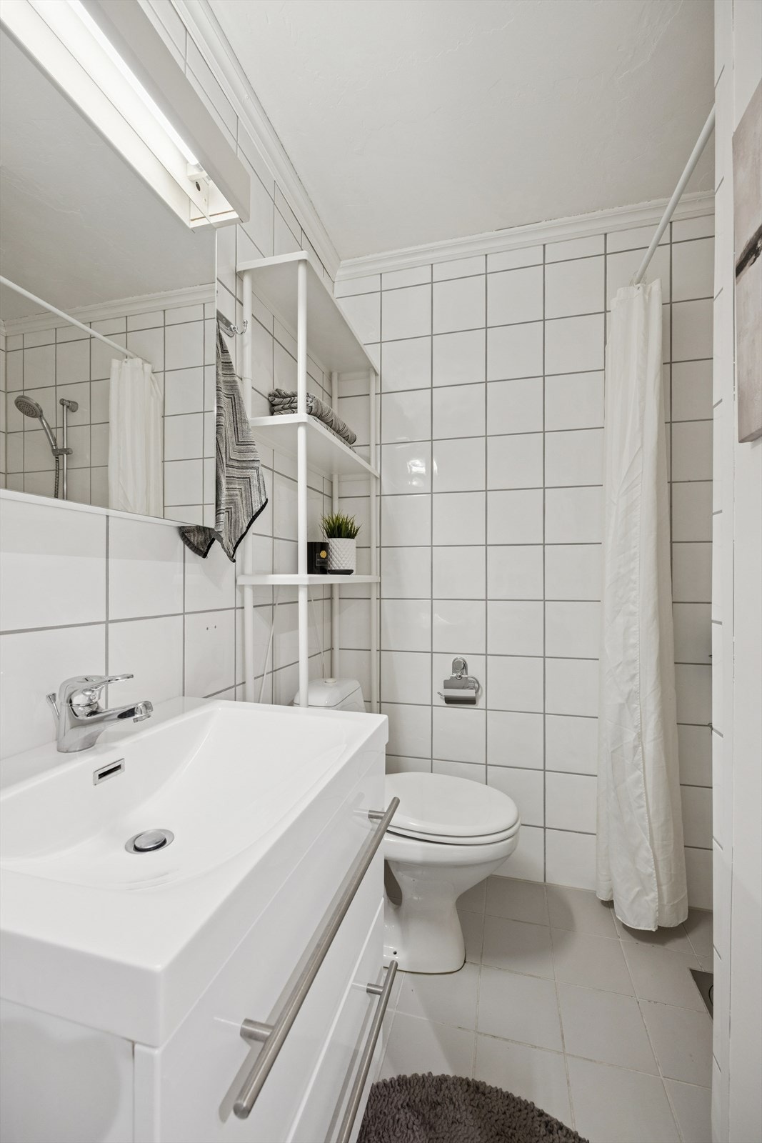 Lyst og pent flislagt bad. Galleribilde